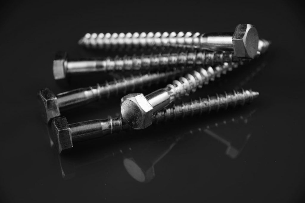 group of hex head bolts in darkness